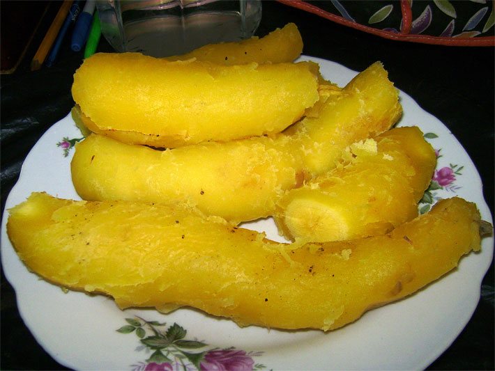 Geschälte und gekochte gelbe Arakacha-Knollen auf einem weißen Teller