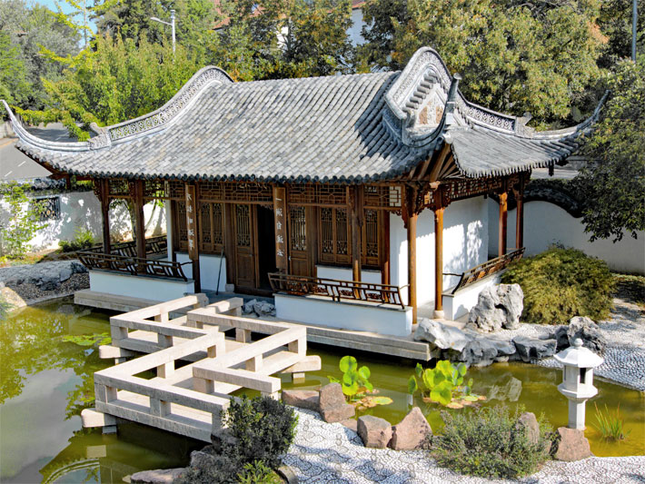 Aussicht vom Pavillon der vier Himmelsrichtungen im Chinesischen Garten Qingyin in Stuttgart auf die Halle der Freundschaft mit dem Pagodendach, den kleinen Teich und die Zickzack-Brücke