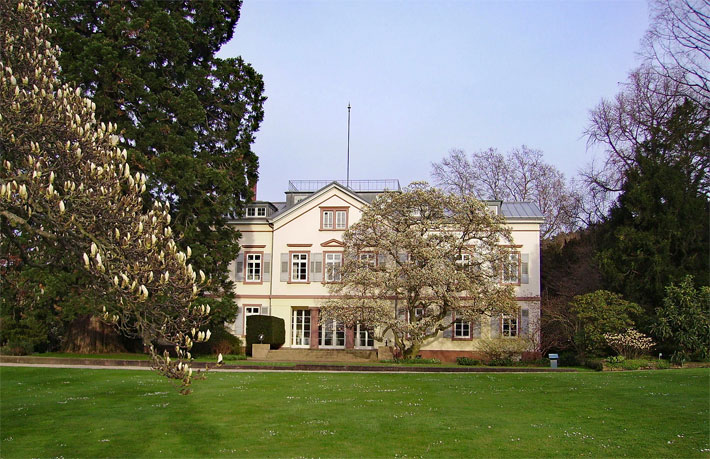 Klassizistische und herrschaftliche Gartenvilla im Schau- und Sichtungsgarten Hermannshof in der Stadt Weinheim mit Riesenmammutbaum und Blütenbäumen