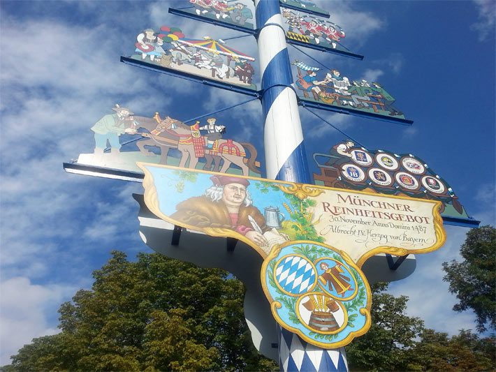 Unterer Teil vom Maibaum auf dem Viktualienmarkt München mit Maibaumschildern und weiss-blauer Bemalung