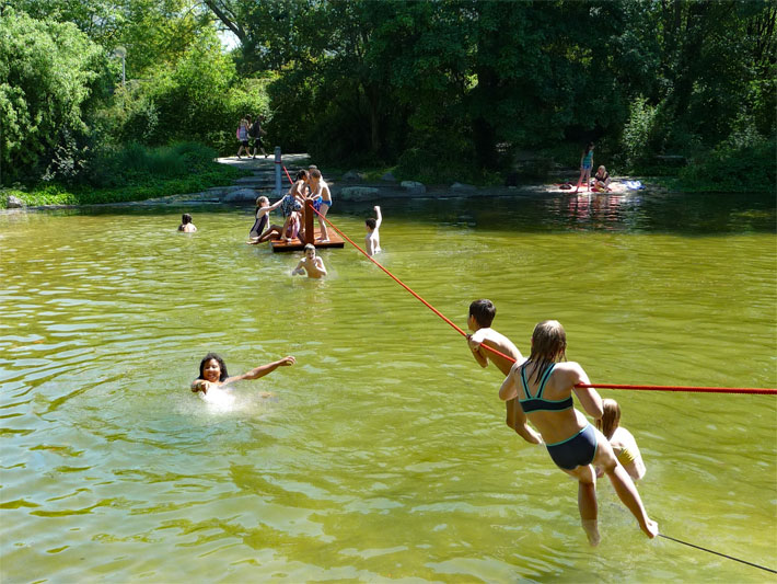 Der Parksee im Herzogenriedpark mit Badegästen im Sommer