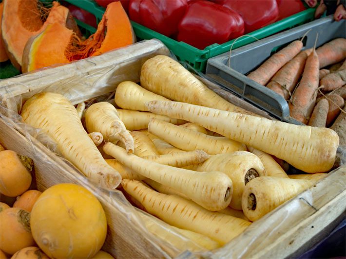 Pastinaken nach dem Ernten auf einem Stand zum Gemüse-Verkauf neben anderen Gemüsearten