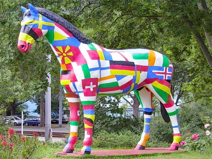 Lebensgrosse Outdoor-Pferde-Skulptur aus Holz im Luisenpark Mannheim mit verschiedenen Länder-Wappen als Dekoration