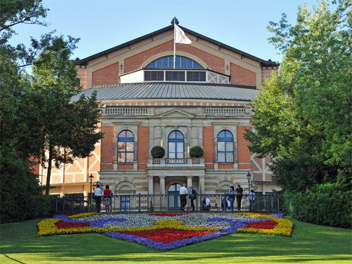 Gelb-rot-lila farbene Blumenrabatte vor dem Wagner-Festspielhaus in Bayreuth