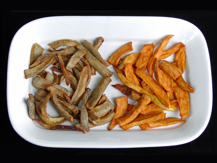 Yacon als Pommes (Fries) frittieren zusammen mit Süßkartoffeln auf einem weißen Teller